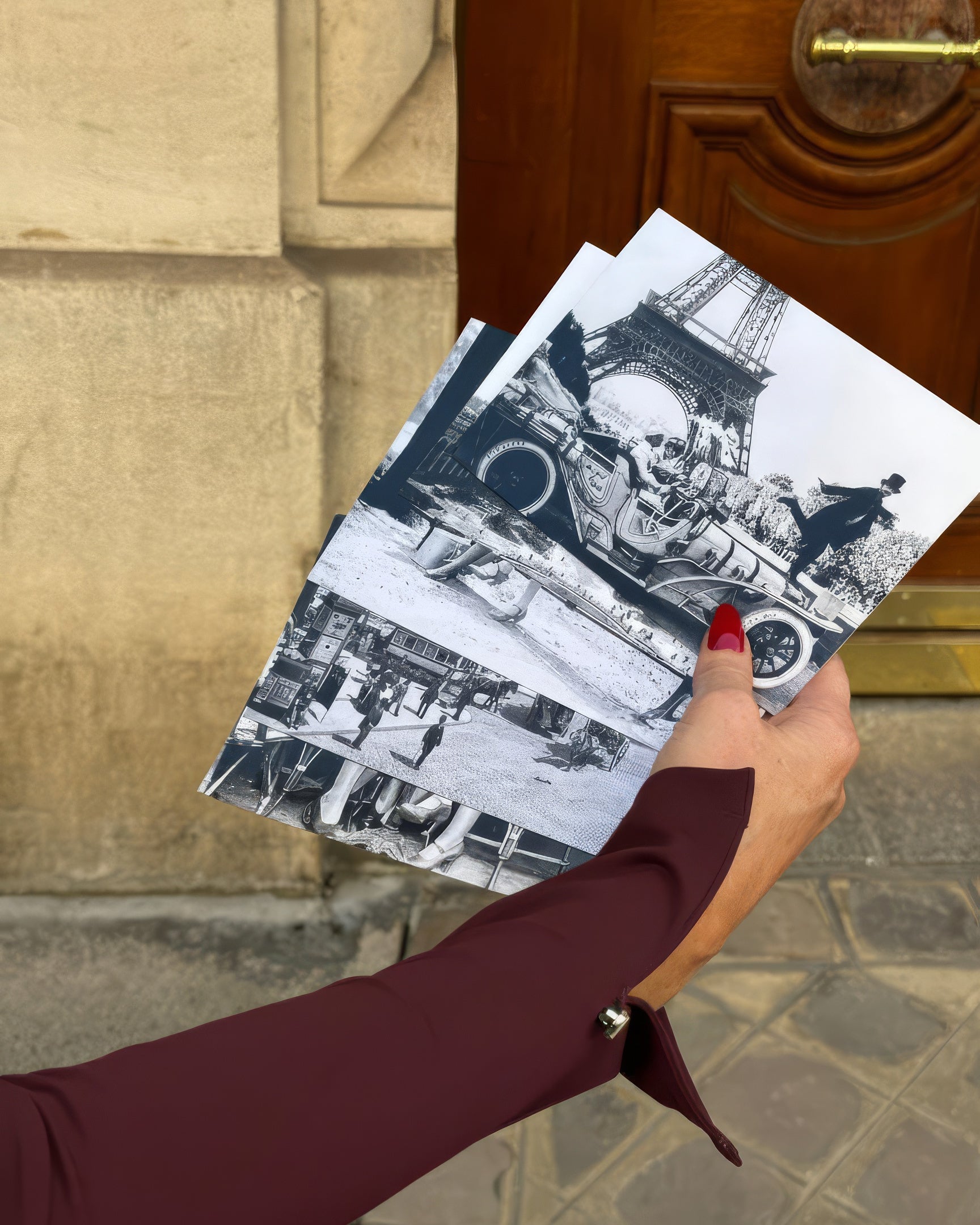 Person with a burgundy sleeve with black and white images of a cityscape, standing in front of a door.