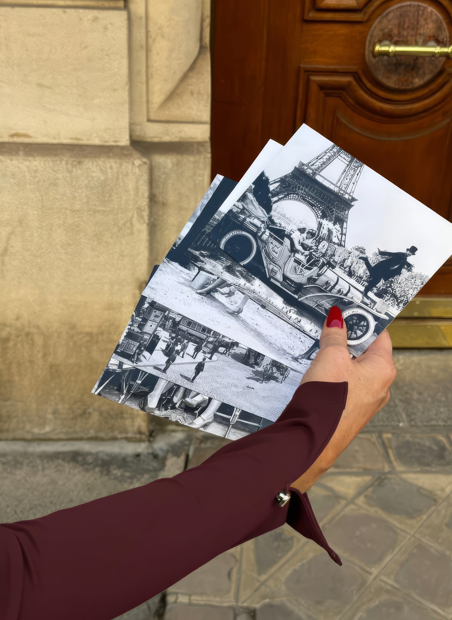 Person with a burgundy sleeve with black and white images of a cityscape, standing in front of a door.