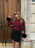 Woman in Ashly Rae bodysuit with Black faux fur cuffs 